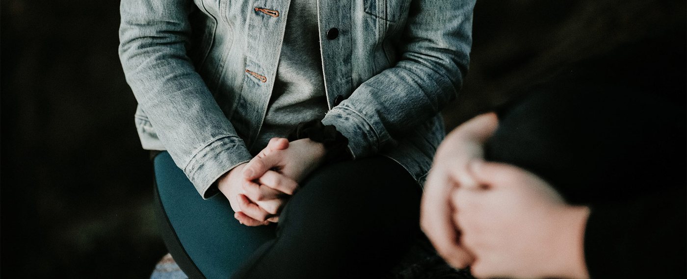 Two people talking, hands clasped