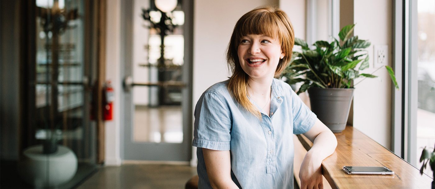 A woman smiling at a desk